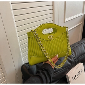 Detail of lime green pleated leather tote bag with gold chain strap and ring buckle