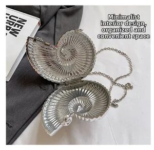Macro view of shell shaped silver bag showing the spiral interior and metal chain