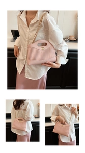 Detailed view of the pink pleated handbag with gold logo and woven chain strap