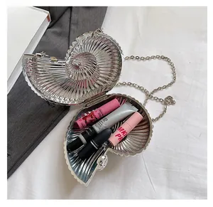 Internal view of shell-shaped silver evening bag showing storage space for cosmetics