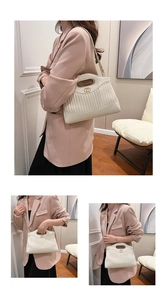 Detail of cream pleated leather tote with gold hardware and circular cutout handle
