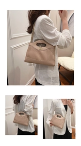 Detail view of beige pleated tote bag with golden chain strap and magnetic buckle
