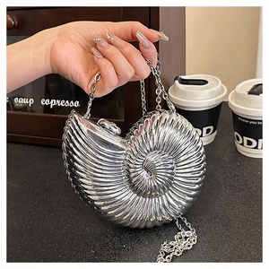 Detailed view of silver nautilus shell clutch bag with metallic spiral texture and chain