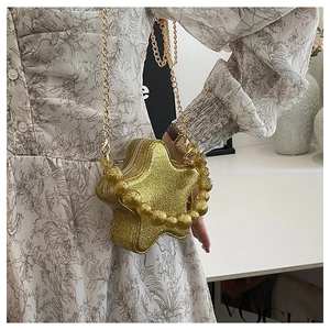 Close-up of star-shaped golden sequin mini bag with pearl handle and metal chain