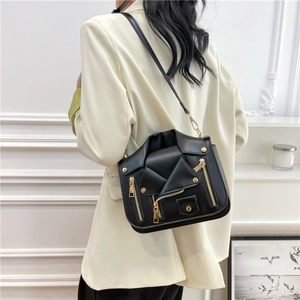 Chic black motorcycle jacket style crossbody bag with gold zippers and studs on model