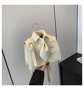 Close-up of cream shirt-shaped tote bag with collar, tie detail and metal hook handle