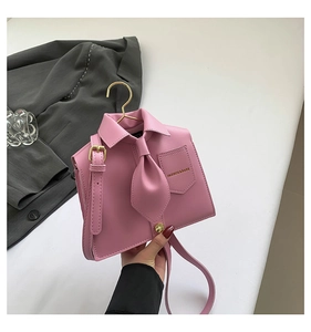 Detail of pink shirt-style crossbody bag with gold hardware and FASHION & BAGS logo