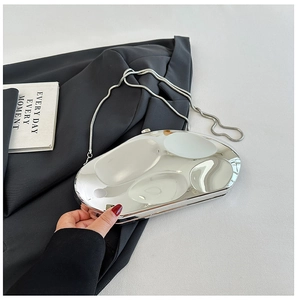 Détail d'un sac boîte en acrylique argent miroir avec une fine chaîne en maille serpent