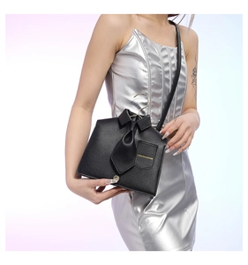 Detail of unique shirt-design PU leather crossbody bag with tie and golden hanger handle