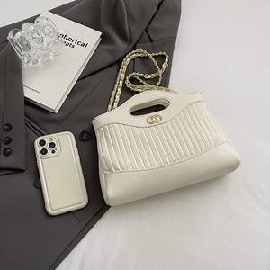Chic beige pleated tote bag with gold chain strap and ring buckle on a grey blazer
