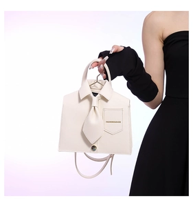 Detail of shirt-shaped tote bag with collar and tie design held by a model