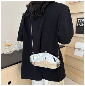 Détail d'un sac boîte métallique argenté irrégulier avec bandoulière chaîne