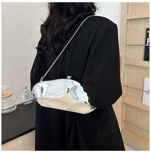 Pochette métallique argentée à effet ondulé avec chaîne élégante portée par mannequin