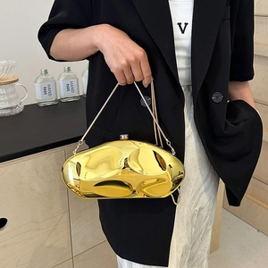 Sac pochette irrégulier en métal doré avec bandoulière à chaîne porté