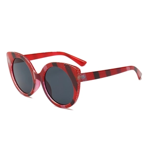 Red glitter oversized cat-eye sunglasses with diagonal stripes and dark lenses