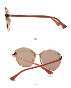 Detail view of brick red geometric sunglasses with gold hinges and brown lenses