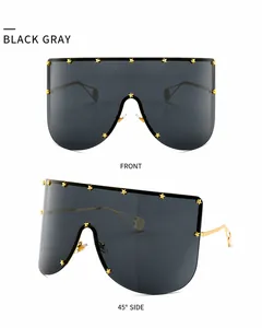 Detail view of mask-style oversized sunglasses with golden star studs and metallic temples