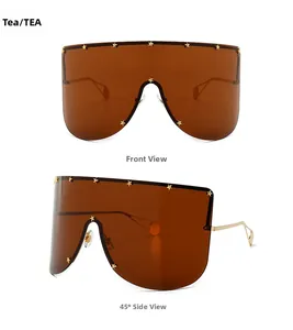 Detail of oversized tea sunglasses with golden star rivets and slim metal temples