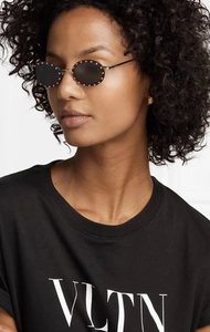 Close-up of stylish round sunglasses with pink rhinestones on slim metal frames