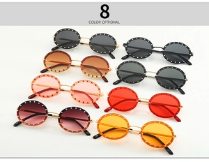 Detail view of round rhinestone sunglasses in eight vibrant colors for trendy street style