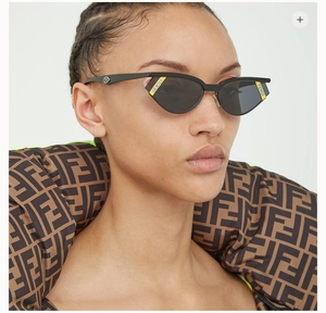 Primo piano di occhiali da sole cat-eye neri con loghi gialli Gentle e Fendi