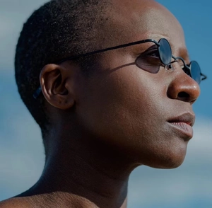 Close-up of retro steampunk sunglasses with small round metal frame on a model