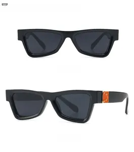 Close-up of retro rectangular sunglasses with orange decorative blocks and gold rivets