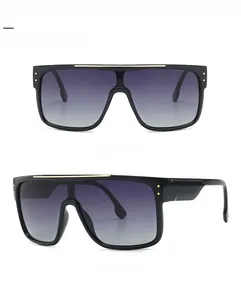 Detailed view of oversized square sunglasses with black frame and golden metal top bar