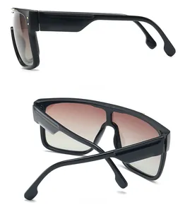 Detail view of oversized square sunglasses with gold rivets and brown gradient lenses