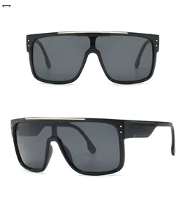 Detailed front and side view of oversized black sunglasses with gold metal top trim