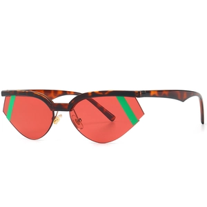 Occhiali da sole cat-eye tartarugati con lenti rosse geometriche e dettagli a righe verdi
