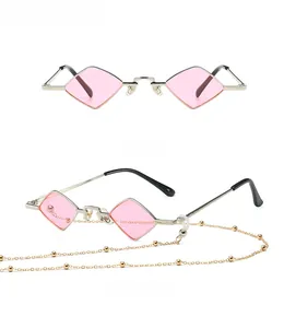 Detail view of silver metal sunglasses with pink lenses and a fine gold bead chain cord