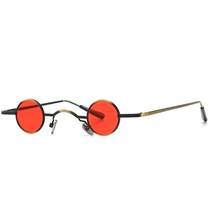 Retro steampunk sunglasses with small round red lenses and thin black gold metal frames