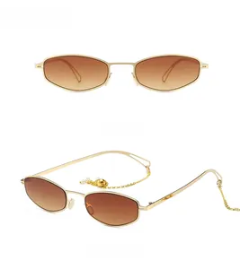 Détail de lunettes de soleil rétro en métal doré avec chaîne en perles et verres dégradés