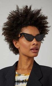 Close-up of black cat-eye sunglasses with unique wavy temple design worn by a model
