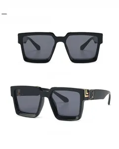Détail des lunettes de soleil carrées noires avec charnières décoratives en métal doré