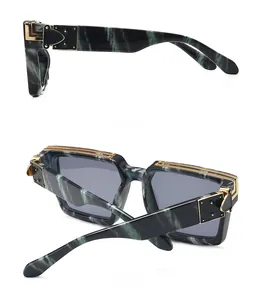 Détail des lunettes de soleil marbré vert foncé avec charnières et rivets en métal doré