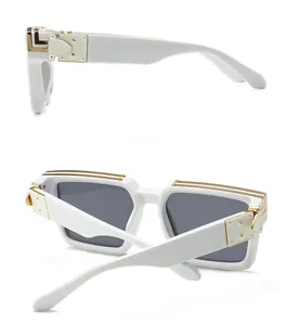 Gros plan sur des lunettes de soleil blanches rétro avec charnières dorées et verres carrés