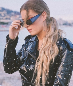 Outdoor street style close-up of trendy square sunglasses and studded leather jacket