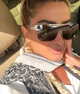 Close-up of oversized shield sunglasses with silver metal temples and patterned scarf