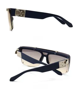 Detail of dark blue retro mask sunglasses with gold metal hinges and gradient lenses