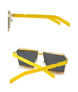 Detail of trendy polygonal sunglasses with yellow temples and gold metal frames
