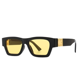 Modern vintage square sunglasses with glossy black frame and amber lenses featuring gold hinges