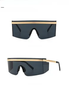 Close-up of gold and black oversized shield sunglasses with grey lenses and front side views