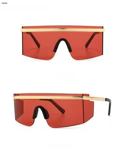 Close-up of gold metal trim and red shield lenses on oversized futuristic sunglasses
