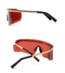 Macro detail of red shield lens with textured gold temples and black tips on modern sunglasses