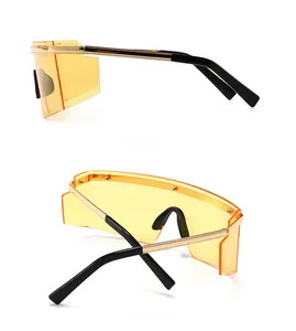 Detail view showing orange shield lenses with golden wave metal trim and black temples
