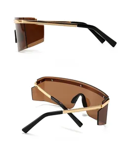Detail view of gold metal sunglasses with textured temples and dark brown gradient lenses