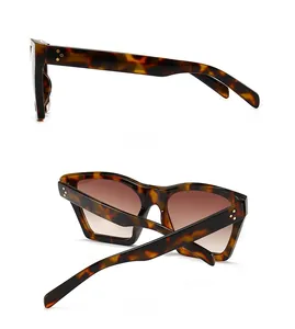 Detail of tortoise shell sunglasses frames featuring gold three-point rivets and gradient lenses