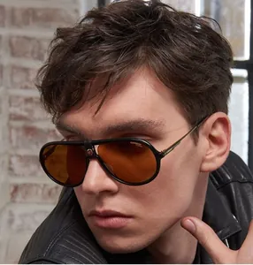 Detail of pilot sunglasses with amber lenses and metallic logo on the black frame